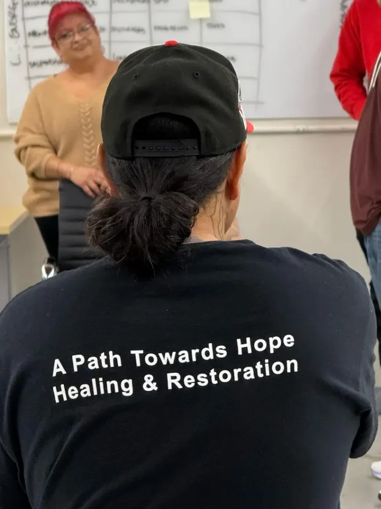 A picture of Kay showing the back of his shirt which says, "A Path Towards Hope, Healing, & Restoration."