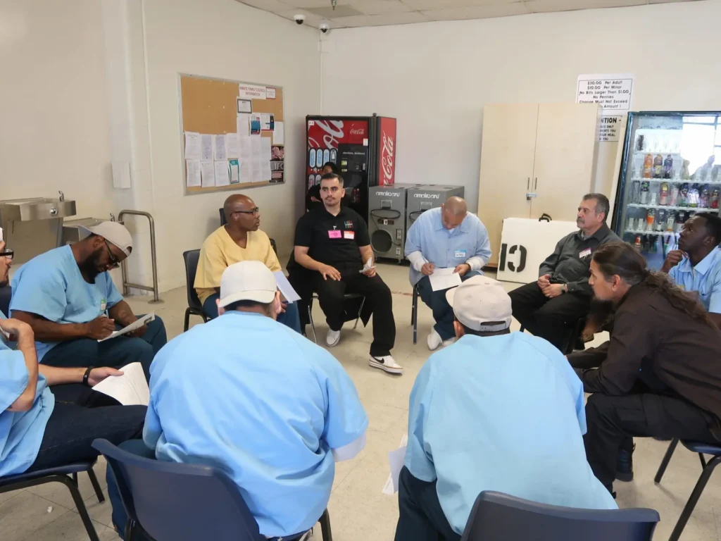 A picture The Prism Way staff facilitating a circle with men who are incarcerated.